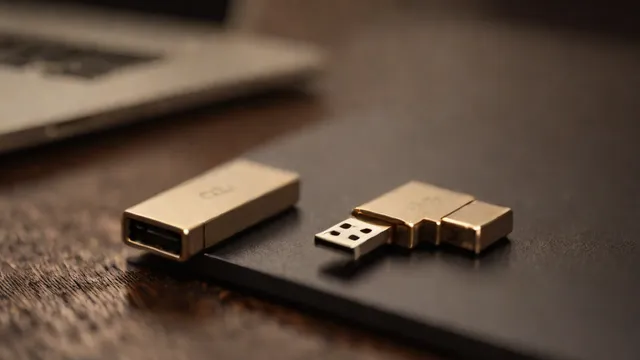 Pendrive de metal conectado al puerto lateral de un ordenador portátil sobre una mesa.