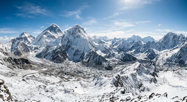 Panorámica de la cordillera del Himalaya con picos nevados bajo el sol de alta montaña.