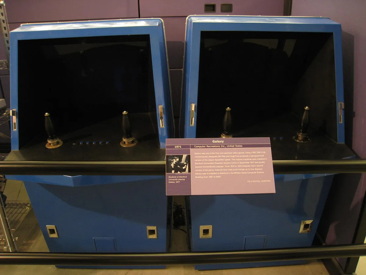 Sala de juegos arcade de los años 80 iluminada por luces de neón y pantallas de máquinas recreativas.