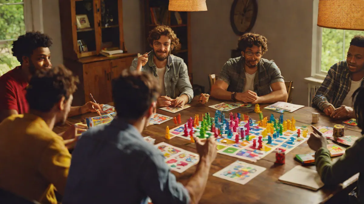 Grupo de amigos reunidos alrededor de una mesa jugando a un juego de rol de mesa con dados y miniaturas.