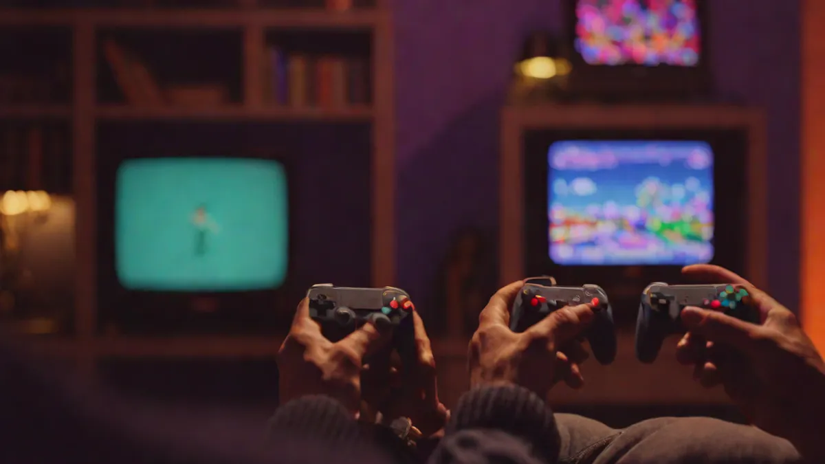 Jugador de espaldas frente a un televisor CRT jugando a un videojuego retro de arte en píxeles.