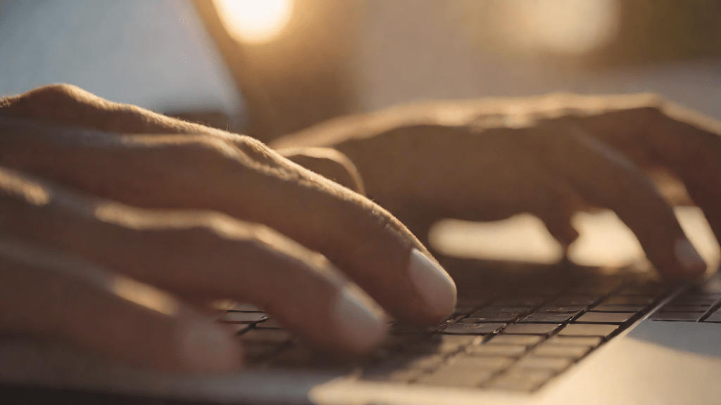 Hands fine-tuning a laptop in a bright morning office setting